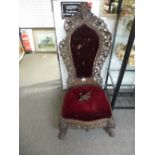 An antique heavily carved low chair probably Burmese, circa 1900, with pierced floral decoration