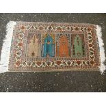 A Turkish silk prayer rug having four central panels, floral bordered and signed, 109 x 62 cms