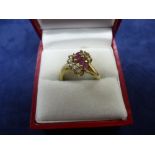 Yellow metal dress ring set with diamond chips and rubies, size O