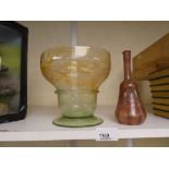 A 20th century glass bowl having a mottled decoration and a red glass bottle with painted swirl