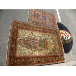 An Indian prayer rug decorated vase of flowers, a hearth rug having armorial design and one