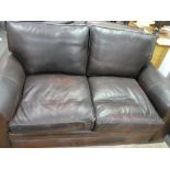 A brown leather two seat sofa with matching armchair