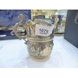 A silver embossed very ornate jug with two handles and two pouring spouts, hallmarked London 1994,