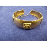 18K yellow gold bangle with applied Egyptian figures, marked 18K, weight approx 30g
