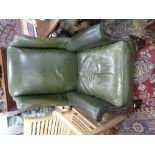 A green leather wing armchair on square legs