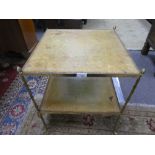 A square brass two tier table having tooled leather decoration, 46.5cms