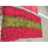 A Turkish Tulu rug having green central stripe and one other red Tulu rug, the largest, 224 x 130cms