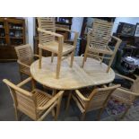 A modern teak extending garden table and a set of eight open armchairs having slatted design - table
