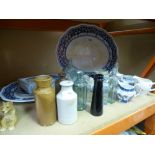 Blue and white charger plates, glass and earthenware bottles, English willow jugs, Wedgewood vase,