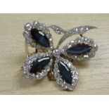 Unmarked yellow metal floral design brooch set with 4 oval sapphires surrounded by approx 63 small