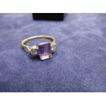 1920s 18ct yellow gold dress ring with central baguette cut amethyst franked with diamonds, size