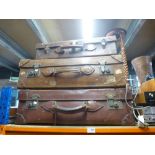 Three leather vintage suitcases of varying sizes