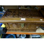 A carved wooden box with a flower and fern detail, having two small drawers and finished with
