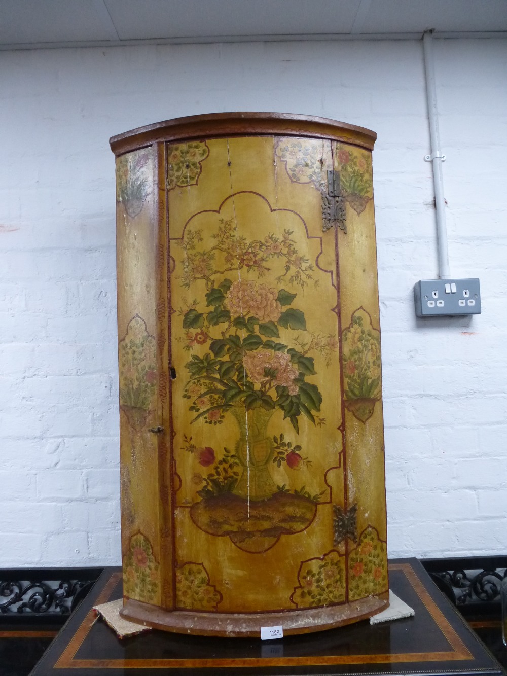 A late 18/ early 19th Century painted bow fronted corner cupboard probably Dutch, showing its