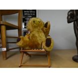 A 1960's Bear with growler and bells in ears, sat on a deck chair
