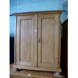 Stripped pine 2 door cupboard with internal shelves on bun supports.