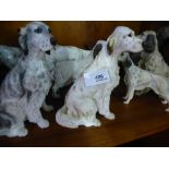 A shelf of dog figures, mostly setters