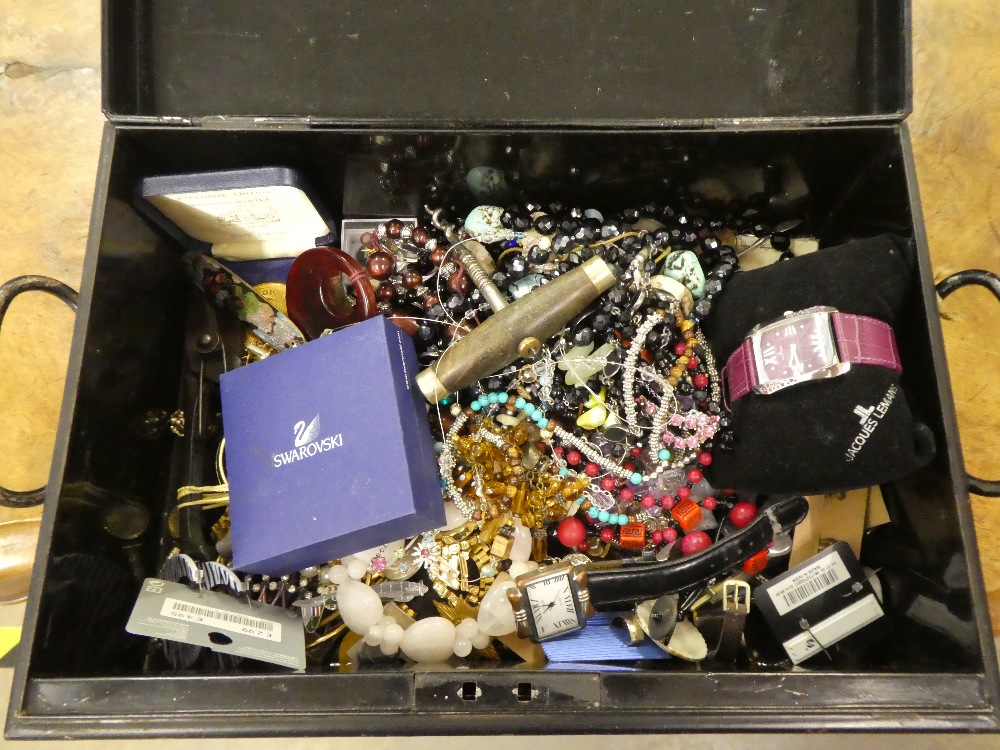 A black metal box containing a small quantity of costume jewellery