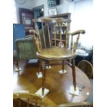 A pair of lead 1920's Bakers Chairs with circular seat and arms.