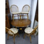 An Ercol circular drop leaf table with four chairs.