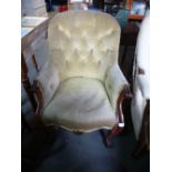 A Victorian mahogany buttonback armchair, having scroll decoration