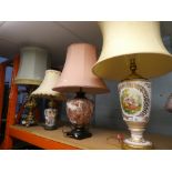 A ceramic table lamp with painted scene of two ladies sat in a garden sat on a metal base, along