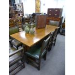 An Oak eight seated table and eight chairs by Titchmarsh Goodwin. The table is a trestle base and