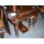 Mahogany extending dining table on turned supports and castors