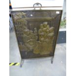 A large pressed brass fire screen of an interior scene with people