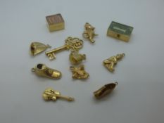 Eleven 9ct yellow gold charms including kettle, boot, key, clog, etc, all marked 375, total weight