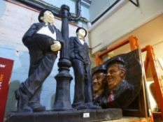 A large resin figure of Laurel & Hardy leaning agaist a lamp post along with an oval plaque also