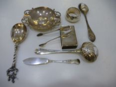 A silver lot containing spoons, tongs, napkin ring, dish, knife and matchbox cover, some marked