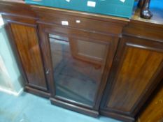 A Victorian mahogany breakfront cabinet having central glazed door on plinth base