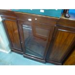 A Victorian mahogany breakfront cabinet having central glazed door on plinth base