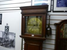 A dark oak grandfather clock with a brass dial