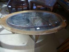 A vintage oval coffee table having inset glass top