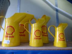 Five Shell oil cans