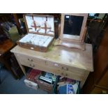 A pine side table having three drawers and a pine dressing mirror