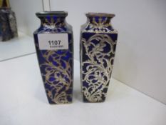 A pair of colbalt blue heavy vases approx height 15cms with ornate white metal flower decoration AF