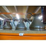 A set of 4 graduated copper measuring jugs