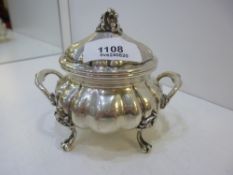 A silver decorative pot with lid and two handles of a foreign background, marked 800, on four claw