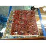 Three rugs, two are modern and one is older having a red background with octagonal and circle