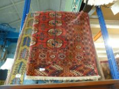 Three rugs, two are modern and one is older having a red background with octagonal and circle