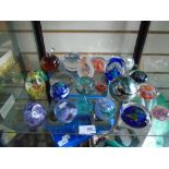 A shelf of glass paperweights including Isle of Wight glass, Caithness, Medina glass