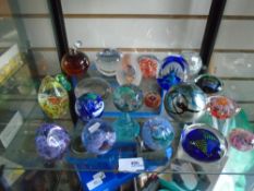 A shelf of glass paperweights including Isle of Wight glass, Caithness, Medina glass