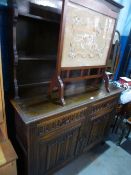 A reproduction oak dresser and rackback having linen fold doors