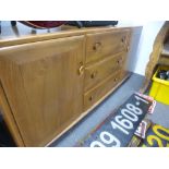 An Ercol medium oak sideboard, having three central drawers, 155cms