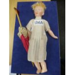 A small doll marked 'K' with a vintage parasol