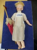 A small doll marked 'K' with a vintage parasol