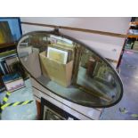 A lead backed oval bevelled edged mirror and two framed pictures